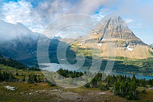 Hidden Lake and pyramid-shaped Bearhat Mountain in Glacier National Park, Montana, USA. Early morning light and scattered clouds