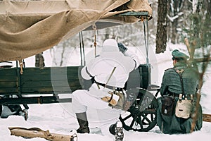 Hidden Re-enactor Dressed As German Wehrmacht Infantry Soldier In World War II Soldiers Sitting In Ambush Near Peasant