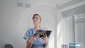 hidden surveillance camera, female doctor wearing glasses checks operation of wireless cctv videocamera using an app on