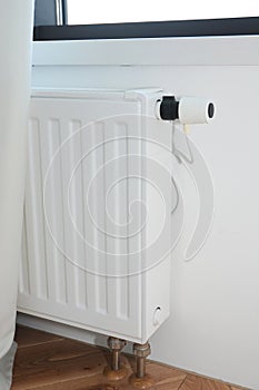 Hide Radiator Pipes. White radiator heating with thermostat for energy saving in house room and hidden heat pipes under the floor