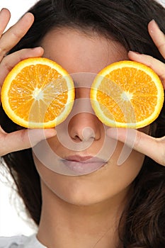 Hiding her eyes with oranges