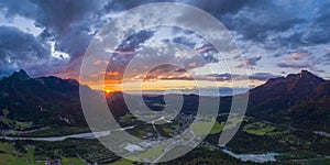 Hiding sun behind mountain chain hahnenkamm with view to village pflach photo