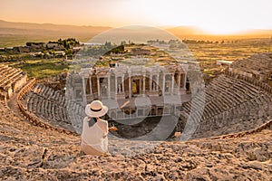 Hierapolis ancient city Pamukkale Turkey, young woman with hat watching sunset by the ruins Unesco