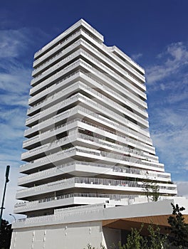 Hieratic building, immaculate white, rising into a blue sky