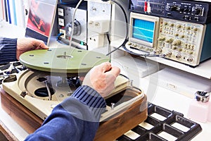 A hifi repairer putting a disc part in a turntable