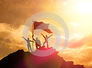 High achiever, silhouettes of three people holding on top of a mountain to raise their hands up.