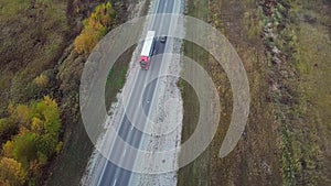 High Aerial view of alone red truck driving an interstate highway with trailer.