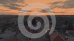 High Aerial View of a Small Town and Approaching a Steeple as the Sun Breaks the Horizon