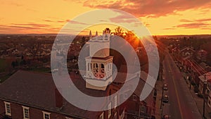 High Aerial View of a Small Town Traveling Down the Main Street as the Sun Breaks the Horizon on a Spring Sunrise