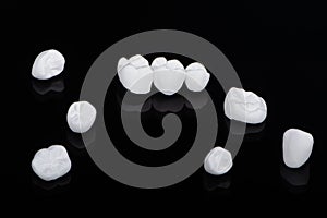 High aesthetic zirconia dentures and crowns on colorful background. Set of single dentures and dental crowns.