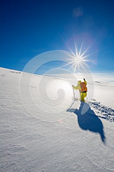 High altitude mountain explorer walking through deep snow