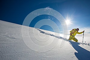 High altitude mountain explorer walking through deep snow