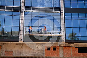 High-altitude work on the exterior walls on a glass building.