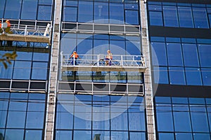 High-altitude work on the exterior walls on a glass building.