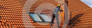 High-altitude worker washing the roof with pressurized water photo