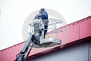 High-altitude works. Professional installation work on a construction building site. Assemblers perform high-altitude installation