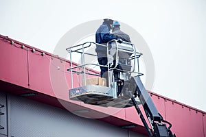 High-altitude works. Professional installation work on a construction building site. Assemblers perform high-altitude installation