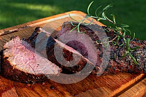 High angel view of grilled beef meat steaks on wooden cutting board .