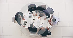 High angle 4k video footage of a group of businesspeople having a meeting together around a table at work during the day