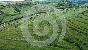 High angle aerial above view of green meadow in the spring, countryside hills
