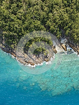 High angle aerial bird\'s eye drone view of the rocky coastline and tiny beaches on ArkhurstIsland