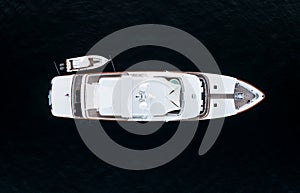 High angle aerial bird`s eye view of a long white luxury yacht with wooden deck