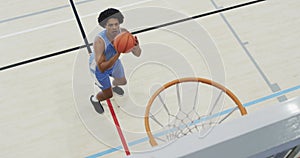 High angle of african american male basketball player shooting ball at hoop on court, slow motion