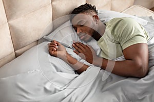 High angle of african american man lying asleep in bed