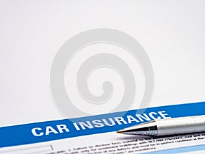 High angle close up shot of a ball pen over car insurance paper document with copy space above