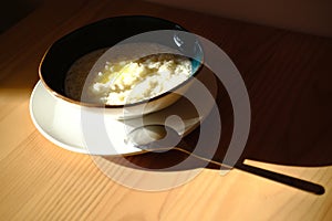 High angle closeup shot of a bowl with porridge on the table - childhood memories concept