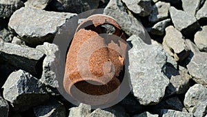 High angle closeup shot of a broken rusty object on the stones