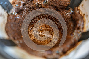 High angle closeup shot of ground coffee in a drainer under the lights