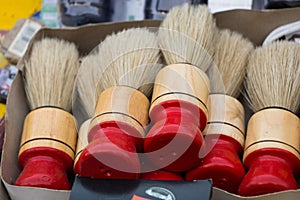 High angle closeup shot of many shoe brushes in a paper box