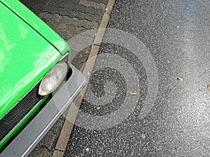 High angle closeup view of the headlights of an old vintage green car