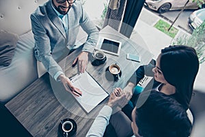 High angle cropped photo of family making a deal with lawyer about their business in cafe with cups of coffee. Men is going to si