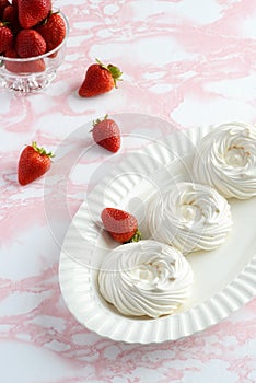 High angle empty meringue nests on a platter with strawberries