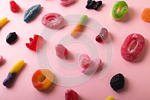 High angle full frame view of multi colored differently shaped sugar candies on pink background