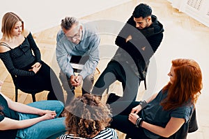 High angle of a group of teenagers sitting in a circle during ps