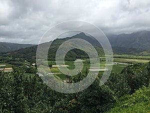 High-angle of Hanalei river valley gloomy cloudy sky background misty mountains, Hawai