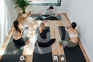 High angle image of a group of people practicing yoga, stretching on the floor