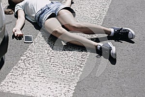 High angle on pedestrian crossing and smartphone next to victim of traffic accident
