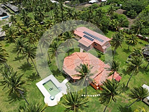 High angle of the Playa El Espino beach with palm trees and red roof villa with a pool