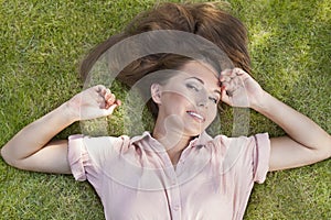 High angle portrait of beautiful young woman lying in grass