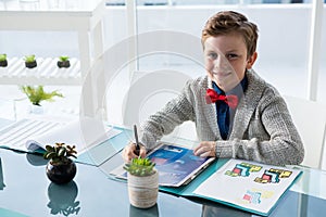 High angle portrait of businessman reading documents while sitting at desk