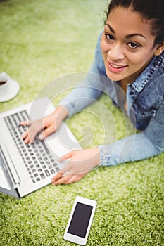 High angle portrait of businesswoman using laptop on carpet