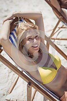 High angle portrait of woman relaxaing on lounge chair at beach