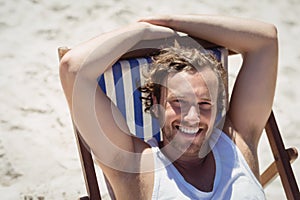 High angle portrait of woman relaxaing on lounge chair at beach