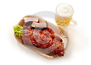 High angle shot of barbeque pork spareribs served with a glass of lager beer