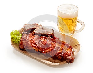 High angle shot of barbeque pork spareribs served with a glass of lager beer