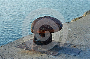 High angle shot of a bollard on the stone pier of the sea